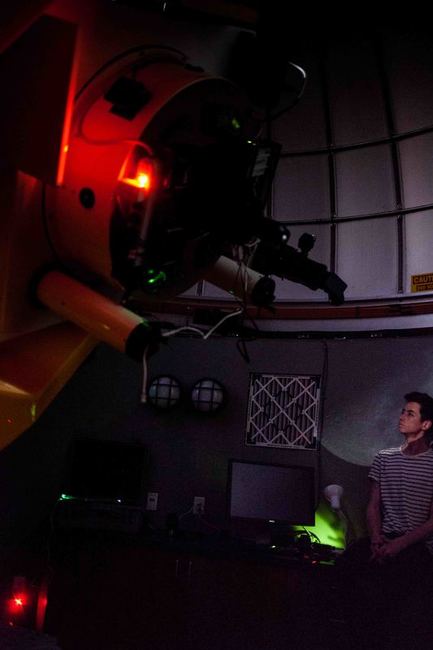 Tim at the telescope inside the observatory dome at night